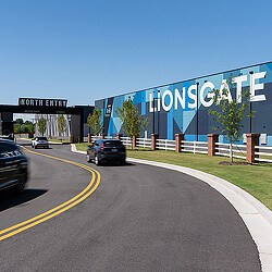 A road with cars on it and a building in the back.