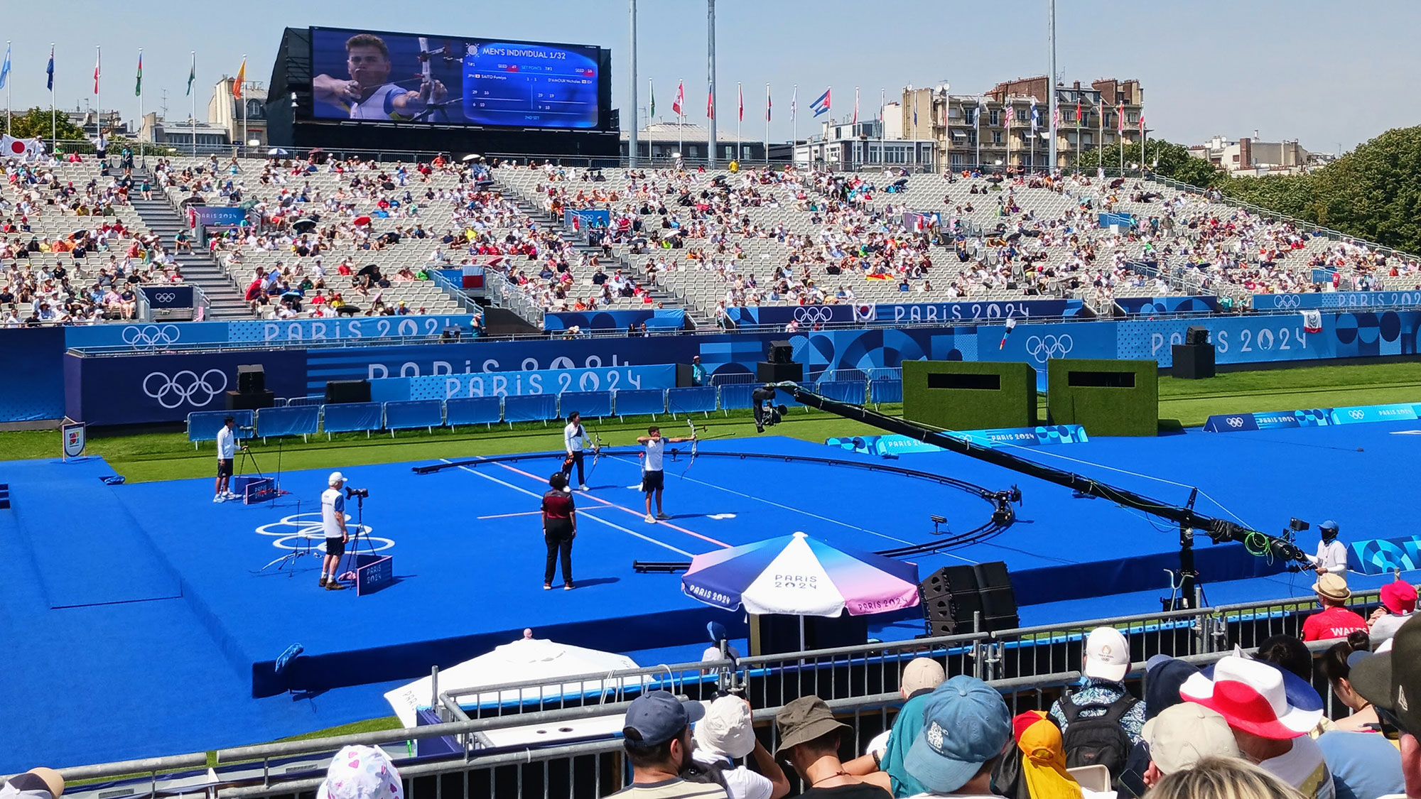 A group of people on a tennis court with a crowd watching.