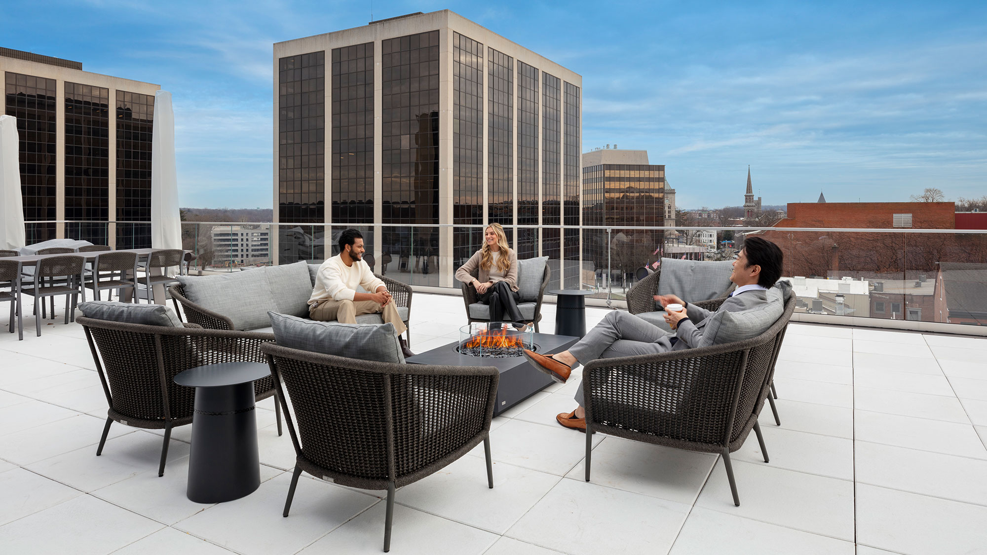 A group of people sitting around a table outside.