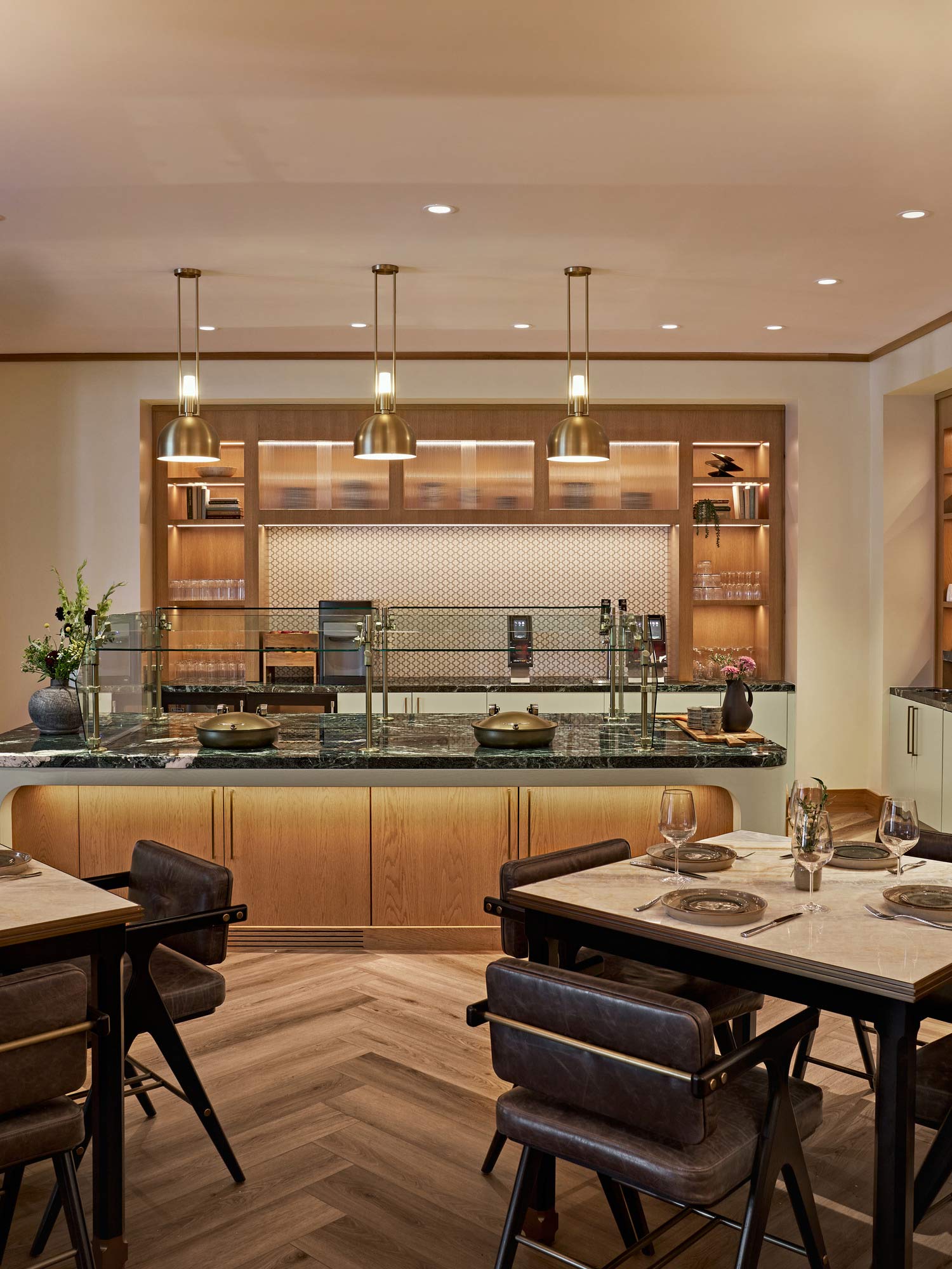 A kitchen with a bar and chairs.