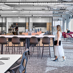 A person standing in a room with tables and chairs.