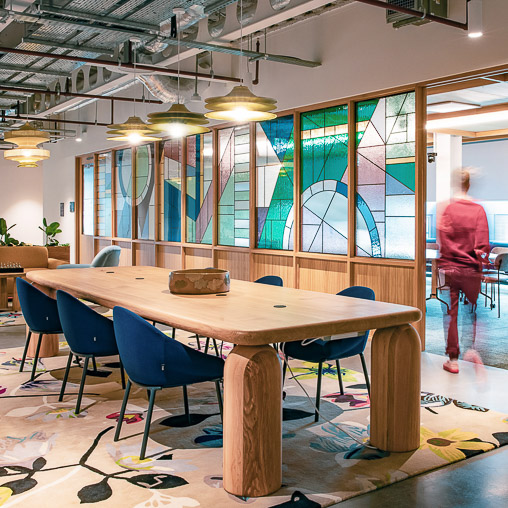 Etsy Dublin workplace with long table, light fixtures, and sliding door with stained glass windows
