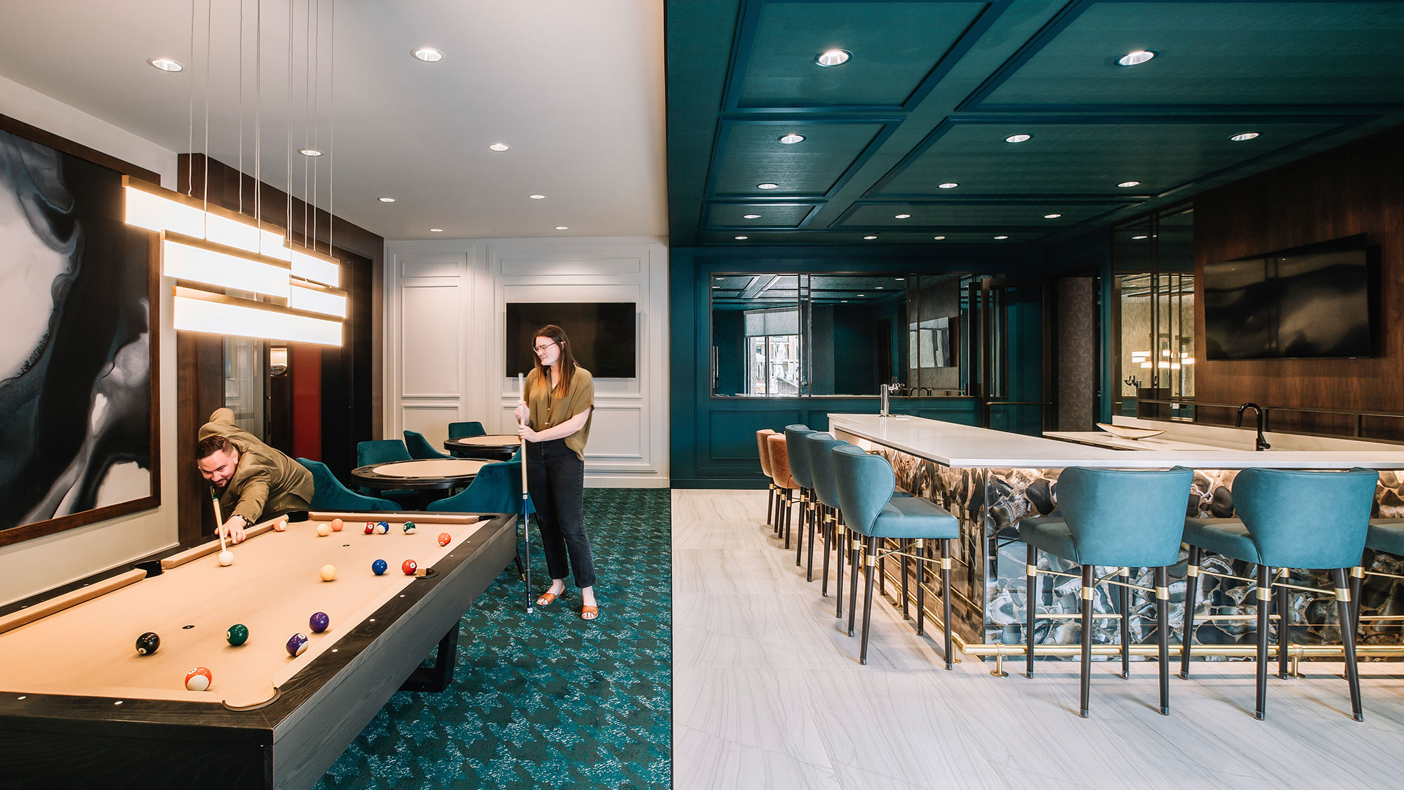 A man and woman standing next to a pool table.