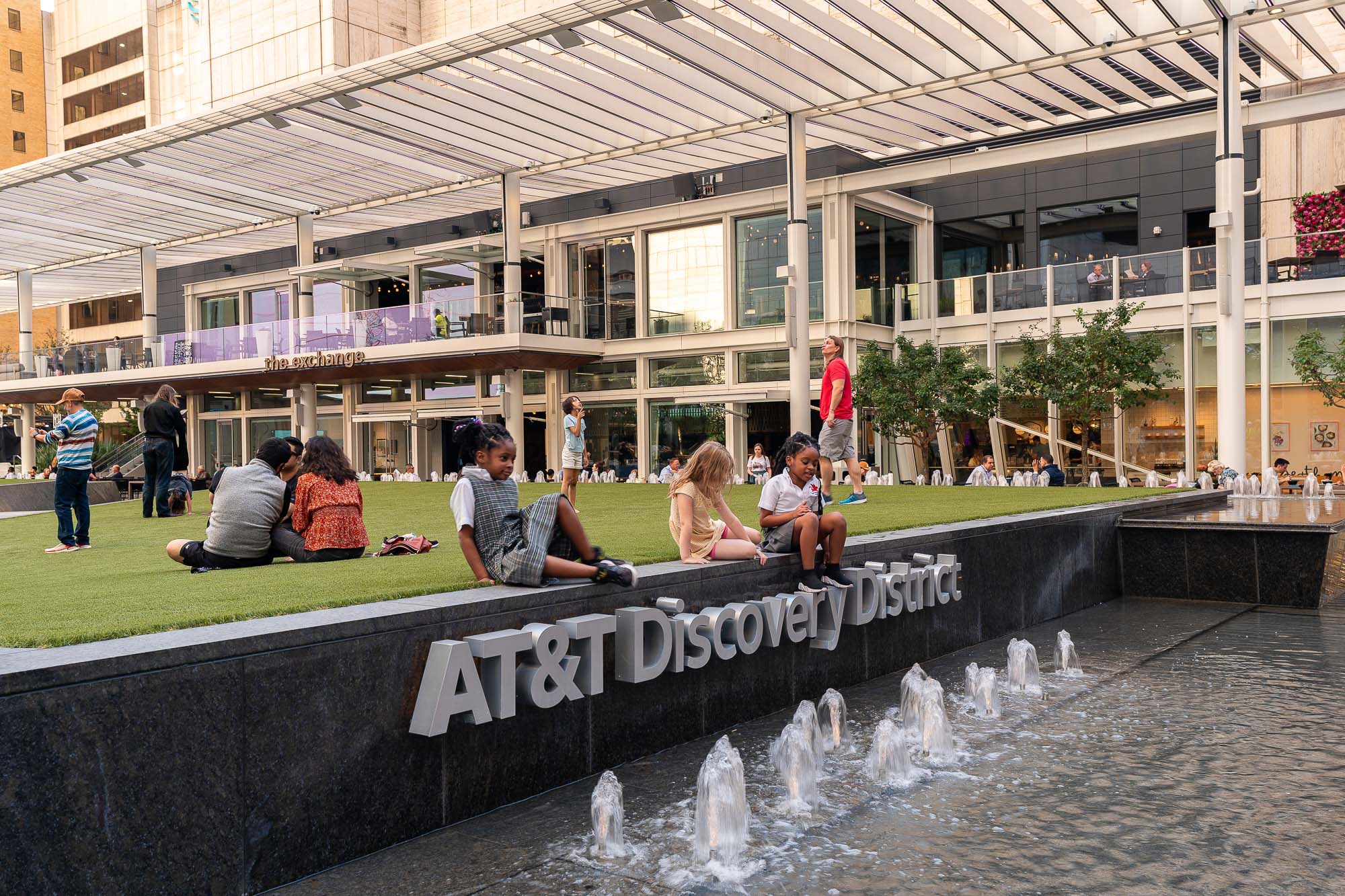 People sitting on a bench next to a fountain.