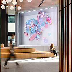 A person sitting on a bench in front of a large screen.