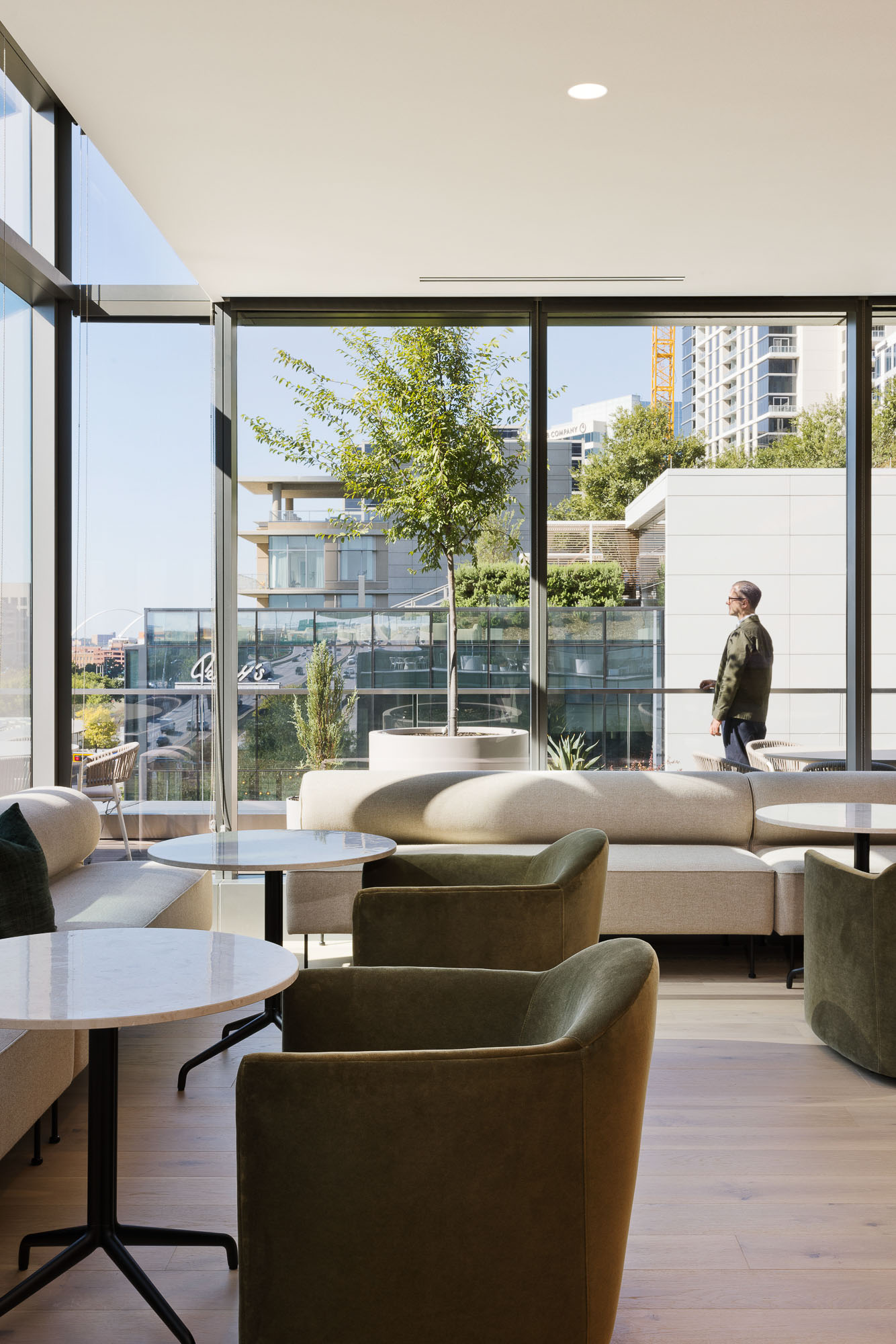 A person walking in a room with a large window and a couch.