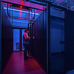 A person standing in a server room.