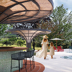 A couple of women walking under an umbrella.