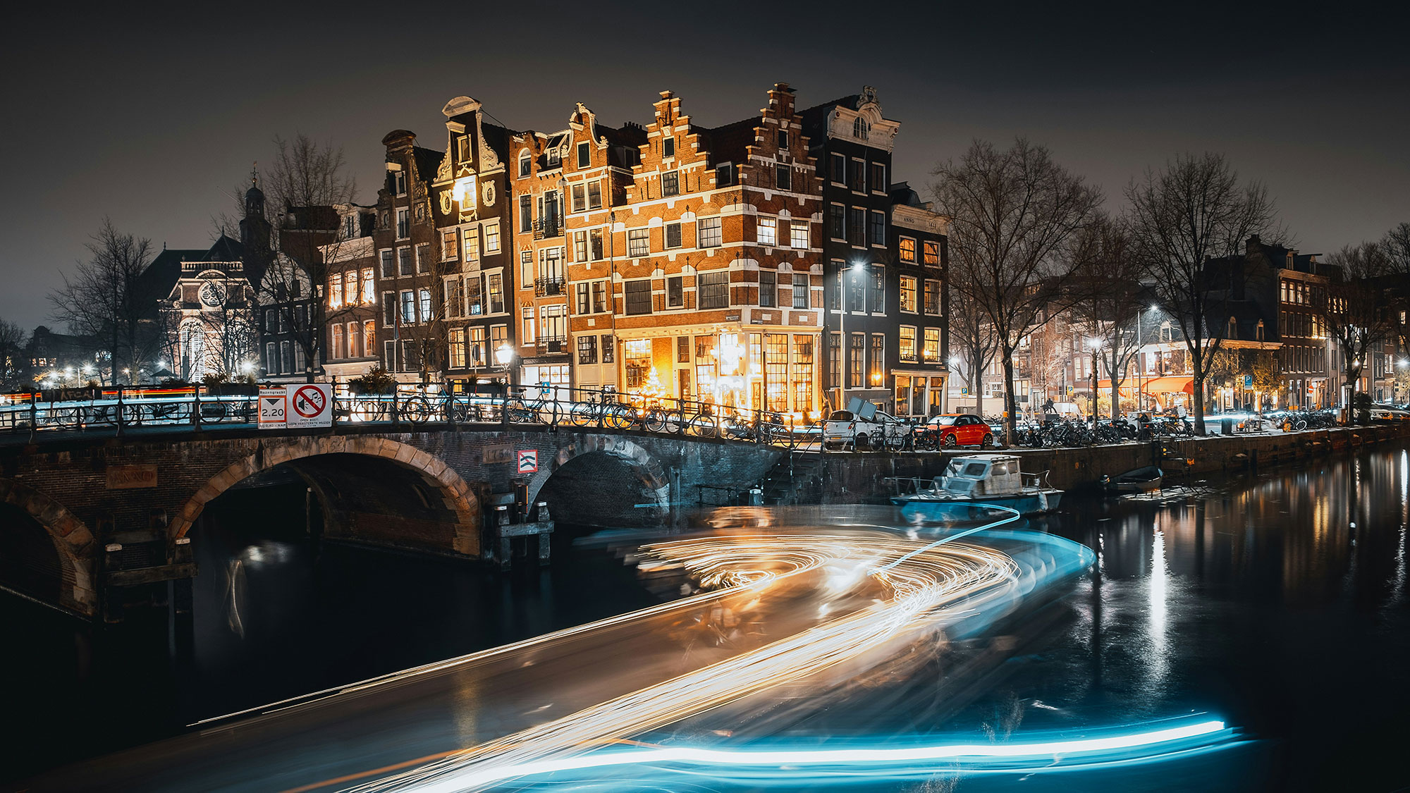 A river with a bridge and buildings in the background.