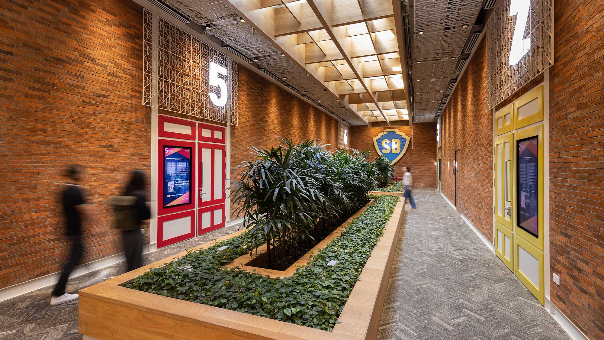 A brick building with a walkway and plants in front of it.