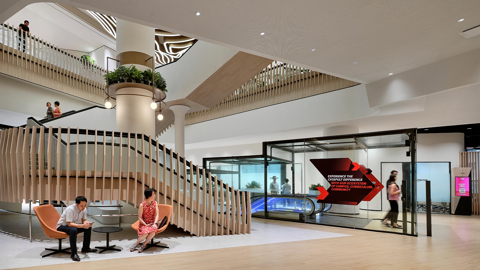 People sitting on benches in a building.