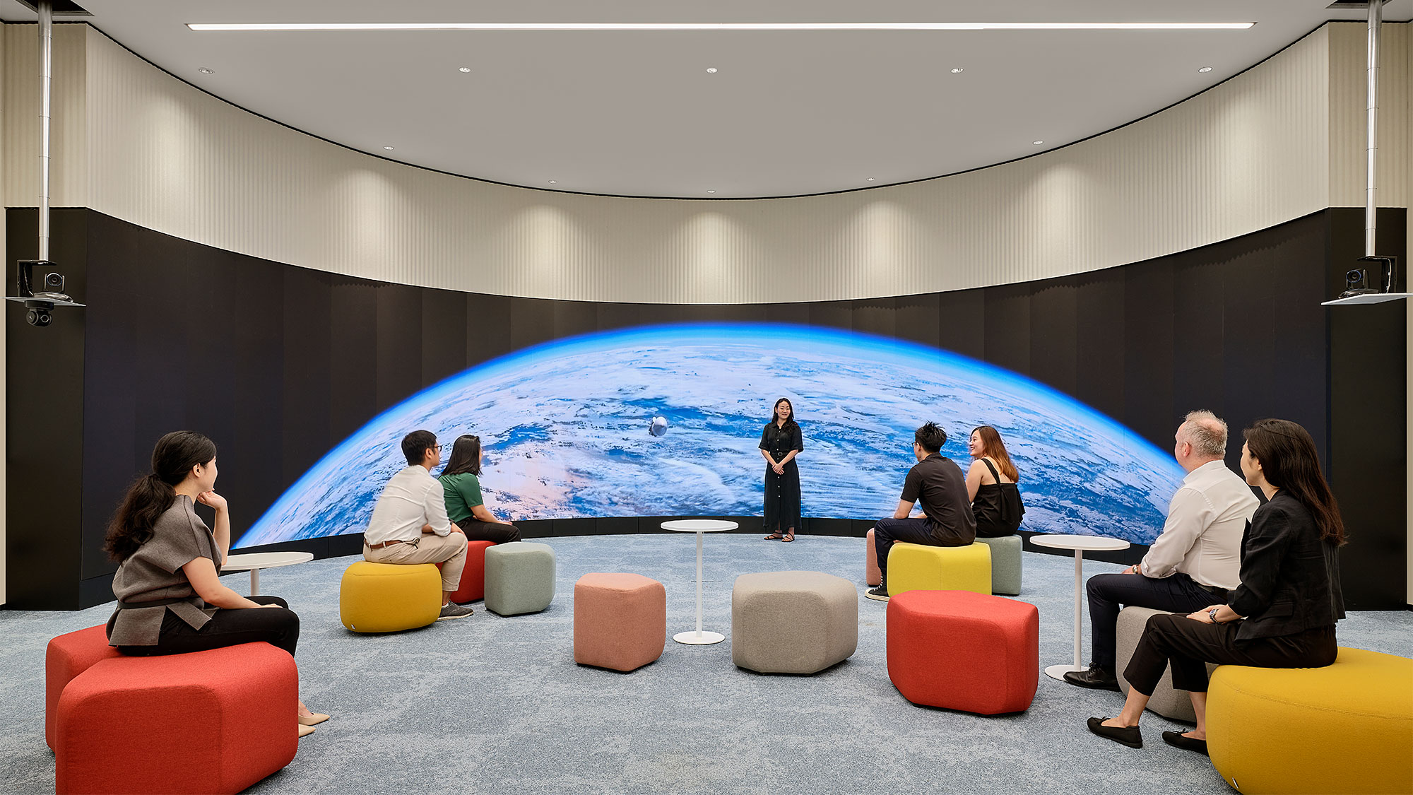 A group of people sitting in a room with a large pool.