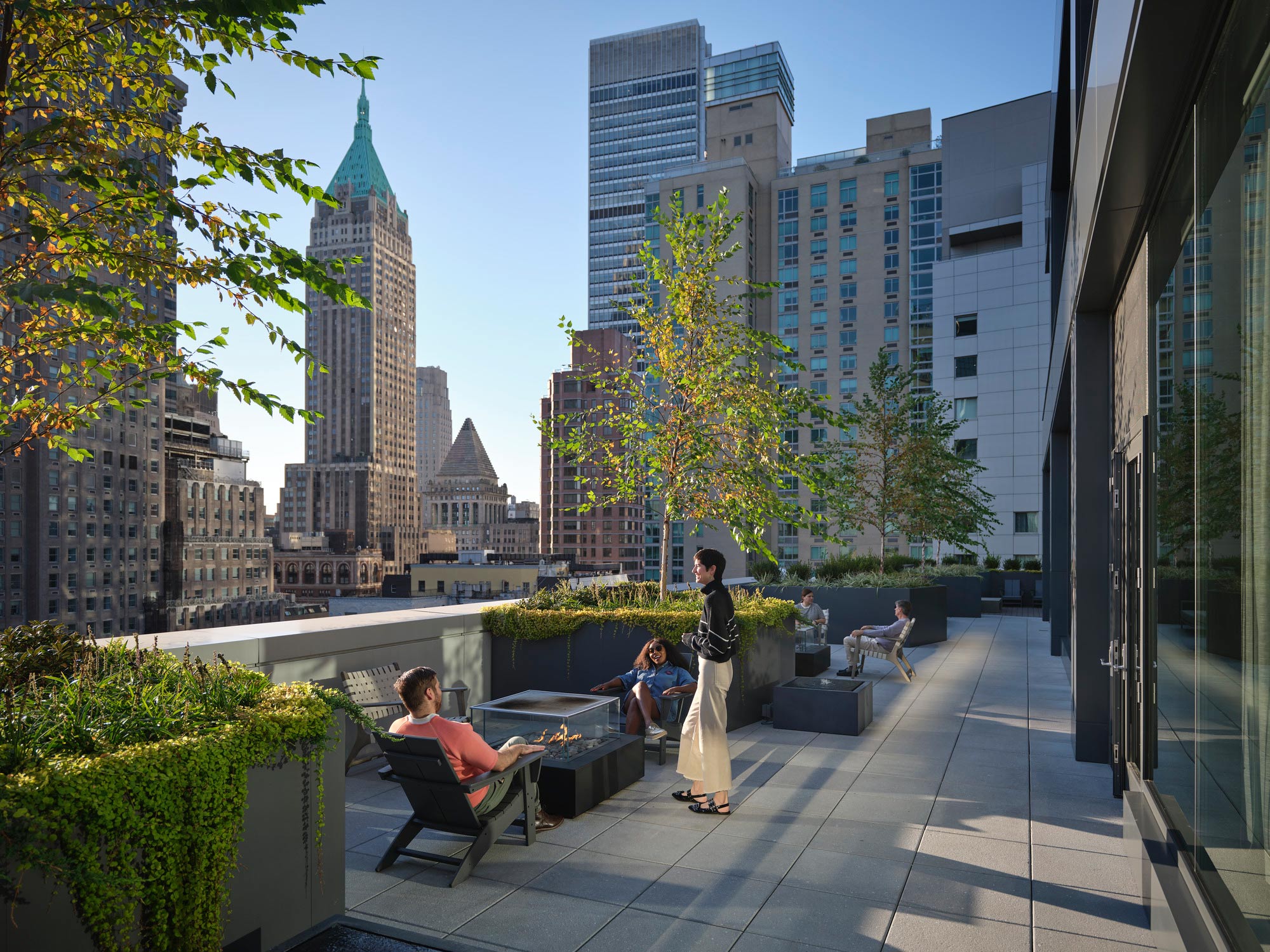 A group of people sitting on a bench in a city.
