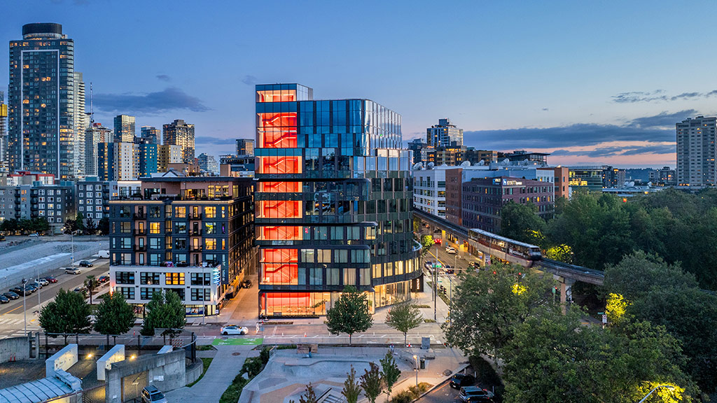 222 Fifth building with illuminated red stairs and Seattle cityscape