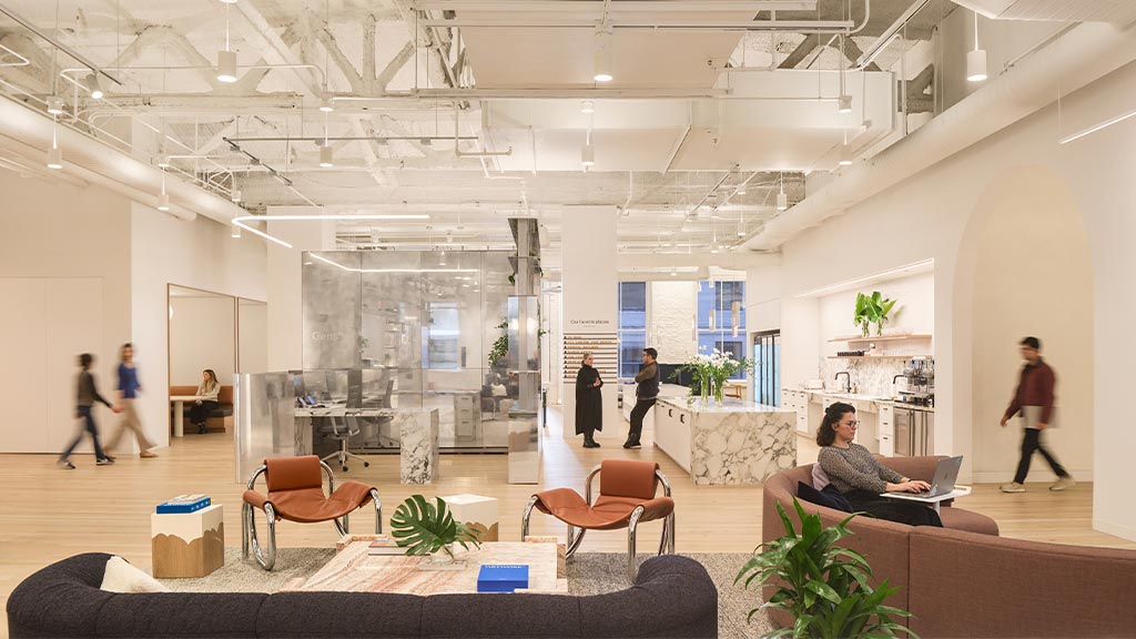 A couple of people are working and socializing in the hallway of Gensler's San Francisco Office.