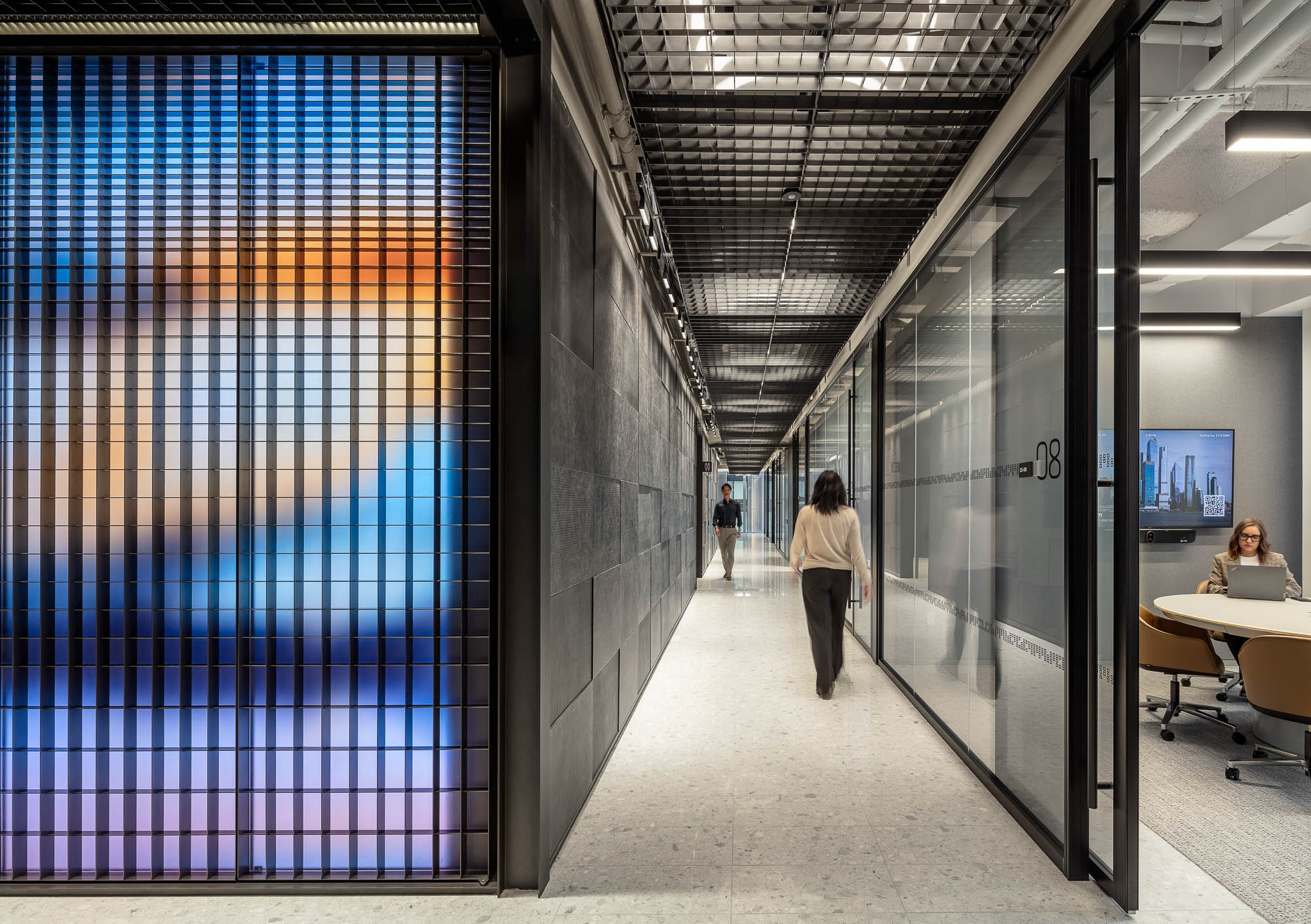 A long hallway with people and computers.