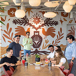 A group of people sitting around a table with food and drinks.