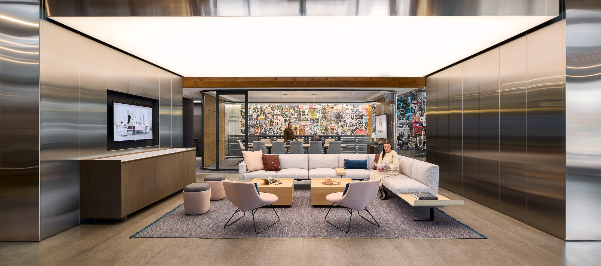 A person sitting on a couch in a room with a large glass wall.