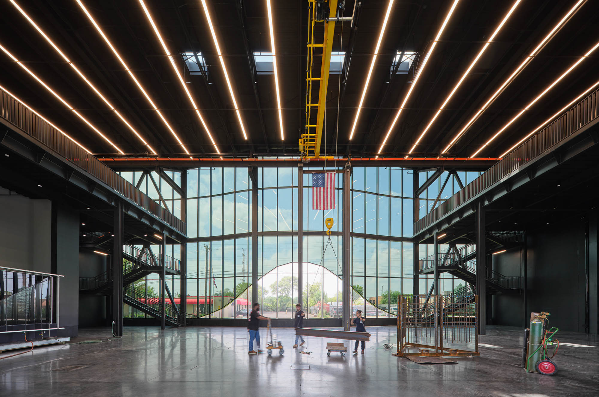 A large building with a large glass window and people walking around.