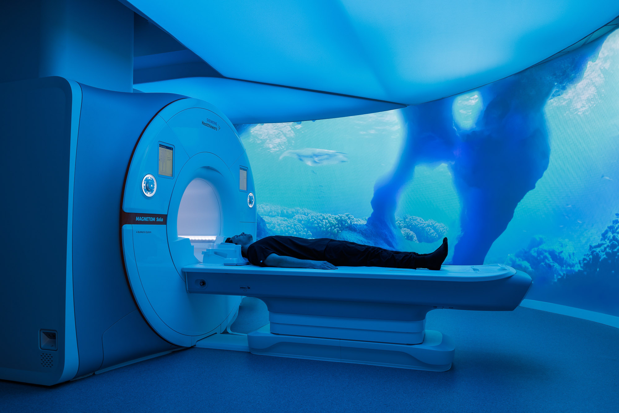 A person lying in a machine.