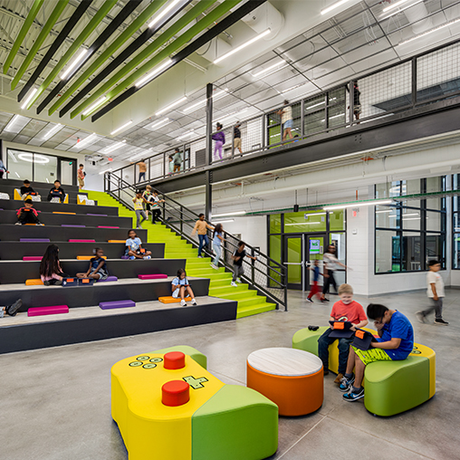 People sitting on benches in a building.