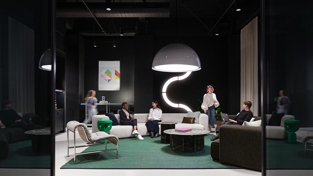 A group of people sitting in a room with a large projector screen.