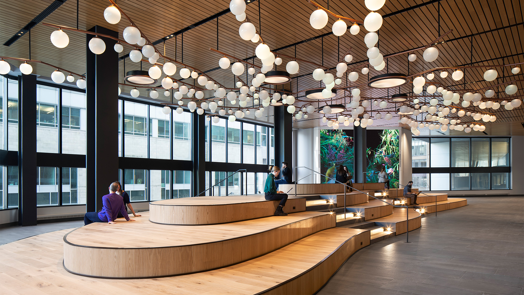 A large room with a large glass ceiling and a few people sitting at a table.