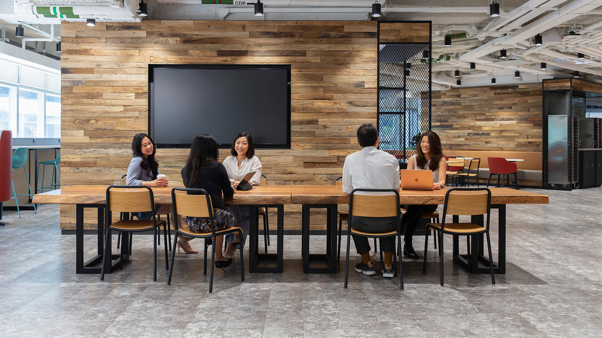 A group of people sitting at a table inside Standard Chartered Bank, Hong Kong, China.
